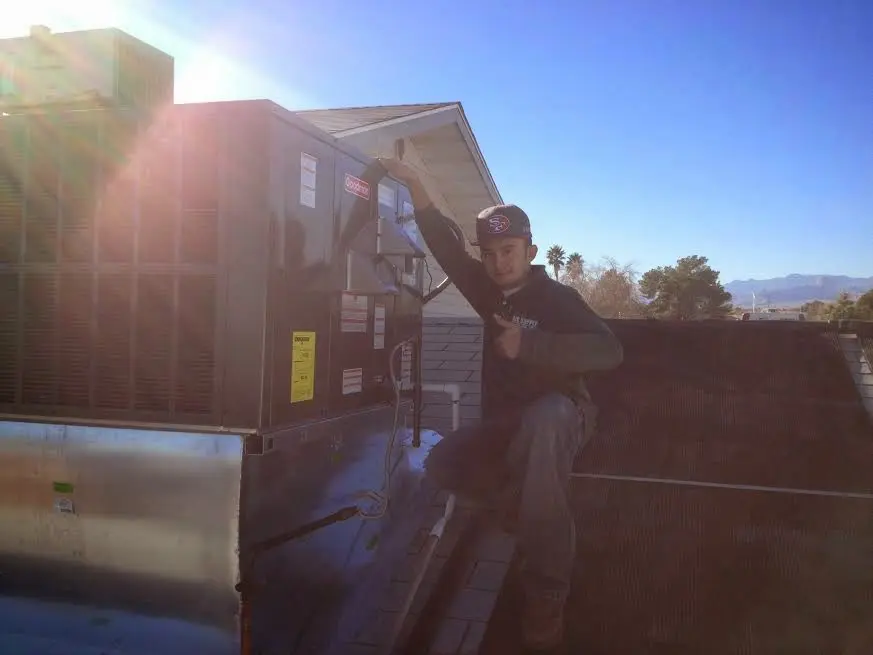 HVAC technician performing Air Duct Repair on a rooftop unit in Gilford